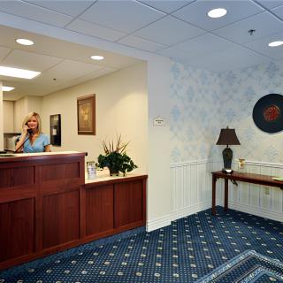 A reception area with a wooden desk and decorative elements.