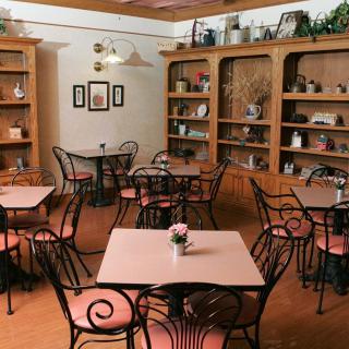 A cozy cafe interior with empty tables and decorative shelves.