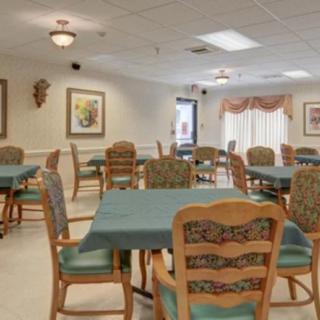 A well-organized dining area with multiple tables and chairs, adorned with artwork on the walls.