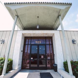 A front entrance of a building with glass doors and a modern canopy.