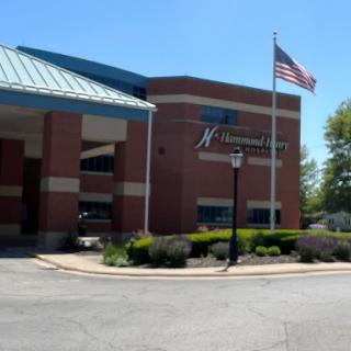 A view of a commercial building with an American flag in front.