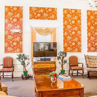 A cozy living room with patterned walls and classic furniture.