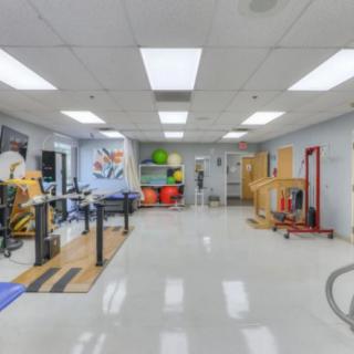 An empty fitness and rehabilitation gym equipped with various exercise machines and therapy tools.