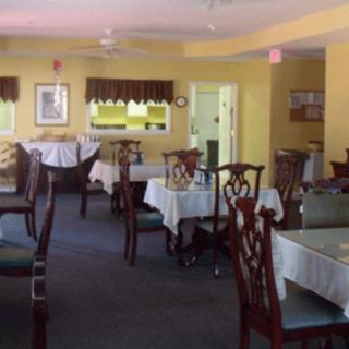 A quiet, empty dining room with neatly arranged tables and chairs.