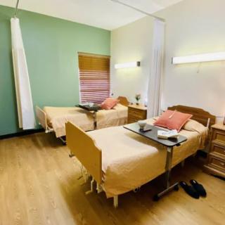 A clean and organized hospital room with two beds and medical equipment.