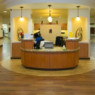 A modern reception area with a wooden desk and decorative lighting.