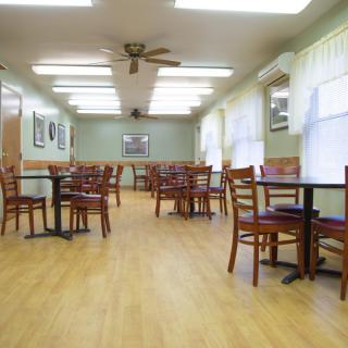 An empty dining area with wooden tables and chairs.