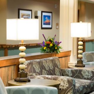 A cozy seating area featuring stylish lamps, decorative flowers, and framed artwork.