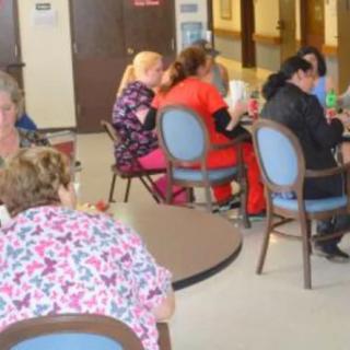 A group of people sitting and socializing in an indoor cafe setting.