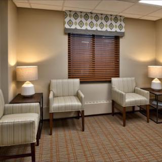 A cozy waiting area featuring patterned chairs, soft lighting, and a warm atmosphere.