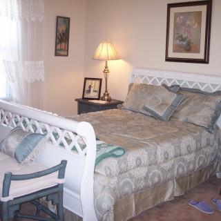 A cozy bedroom with a neatly made bed and warm lighting.