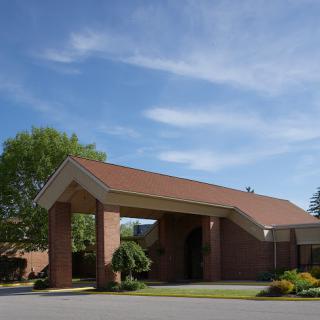 The entrance of a hotel under a clear blue sky.