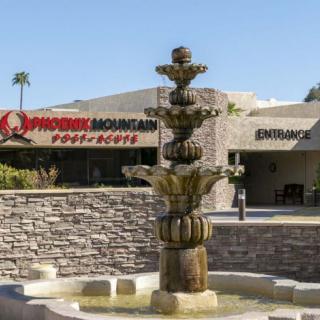 A stone fountain in front of a building labeled Desert Mountain, with an entrance visible in the background.