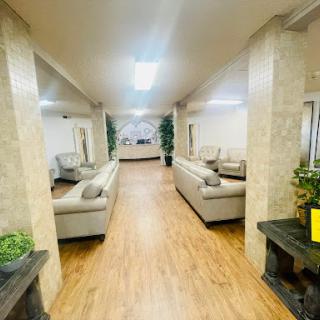 A spacious and modern waiting area featuring comfortable couches and greenery.
