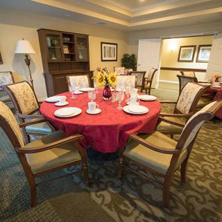 A cozy dining room with a round table set for a meal.