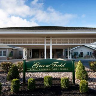 Front view of a retirement home with well-maintained landscaping and clear signage.