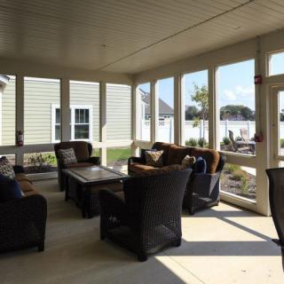 A sunlit porch with comfortable outdoor furniture.