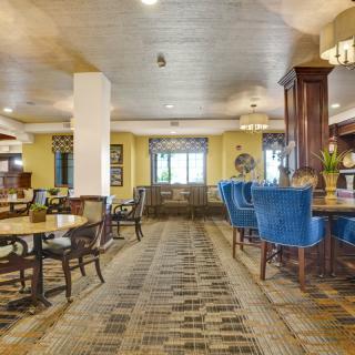 A spacious hotel lounge with elegant furniture and a cozy dining area.