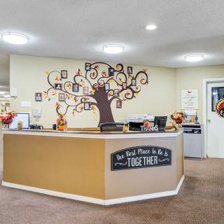A welcoming office reception area with a decorated desk and wall art.