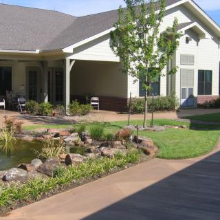 A charming house with a landscaped garden and pond.