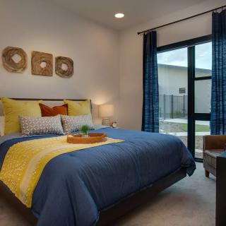 A modern and cozy bedroom with colorful bedding and wall decor.
