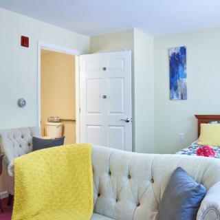 A cozy bedroom with bright yellow accents and comfortable furniture.