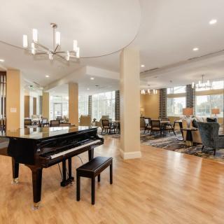A spacious lobby with a grand piano and dining area.
