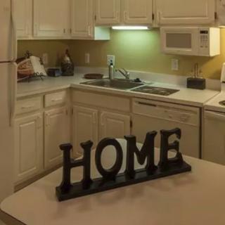A cozy kitchen featuring a 'HOME' sign on the counter.