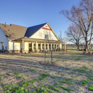 A charming rural house with a spacious yard and trees, bathed in sunlight.