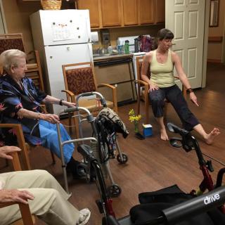 A group of people engaged in a physical therapy session in an indoor setting.