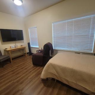A cozy and modern bedroom featuring a bed, a television, and stylish furniture.