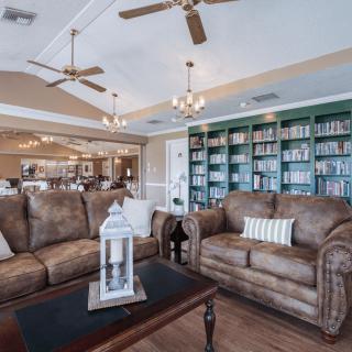 A cozy living room with comfortable sofas, a well-stocked bookshelf, and elegant chandeliers.