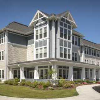 A modern residential building with large windows and well-maintained landscaping.
