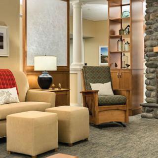 A cozy living room with comfortable seating, a stone fireplace, and well-placed furnishings.