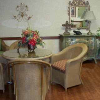 A cozy room with wicker furniture and a floral centerpiece.