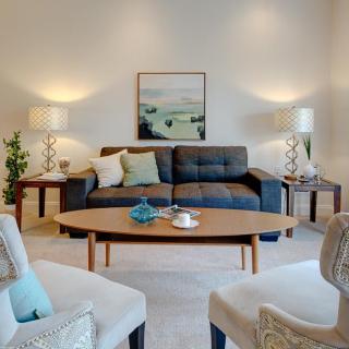 A cozy and stylish living room featuring a modern sofa, wooden coffee table, and warm lighting.