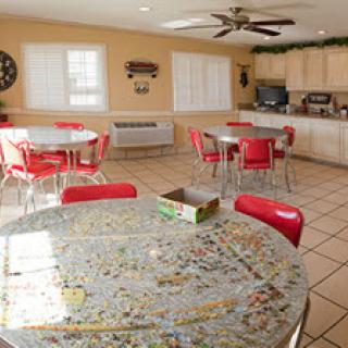A spacious dining area featuring colorful red chairs and a unique puzzle table.