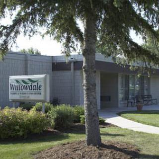 A healthcare clinic building with a sign and surrounding landscaping.
