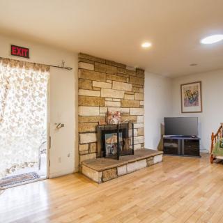 A cozy living room with a stone fireplace and modern decor.