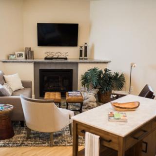 A cozy living room with modern decor, featuring a fireplace and TV.