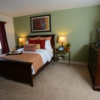 A cozy bedroom with elegant furniture and warm lighting.