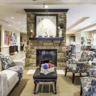 A cozy living room featuring a stone fireplace and comfortable seating.