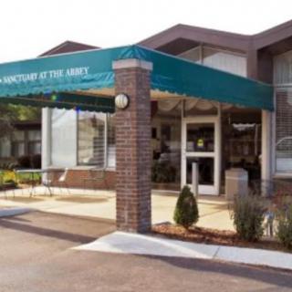 Entrance of a building with an awning and brick exterior.