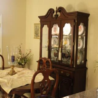 A classic dining room setup featuring a wooden china cabinet and elegantly set table.