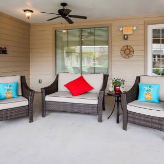 A cozy outdoor patio with wicker seating and colorful pillows.