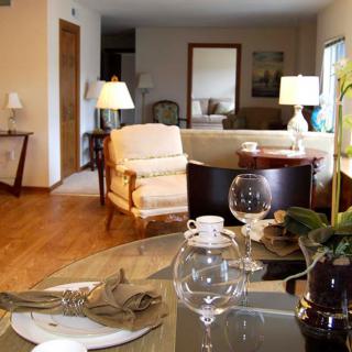 A cozy and modern living room with elegant furniture and a well-set dining table.
