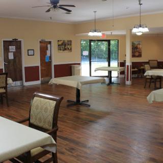 A spacious and inviting dining area with tables and chairs, featuring a warm color scheme and natural lighting.