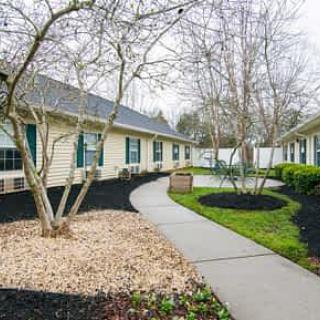 A well-landscaped residential area with a paved pathway and surrounding greenery.