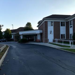 A view of a hotel from the approach road during early morning hours.