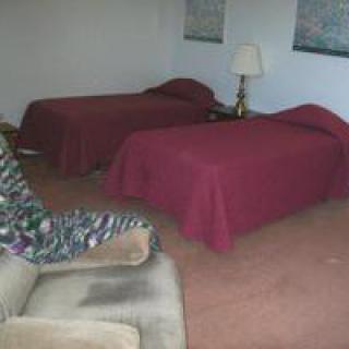 A hotel room with twin beds and a lamp.